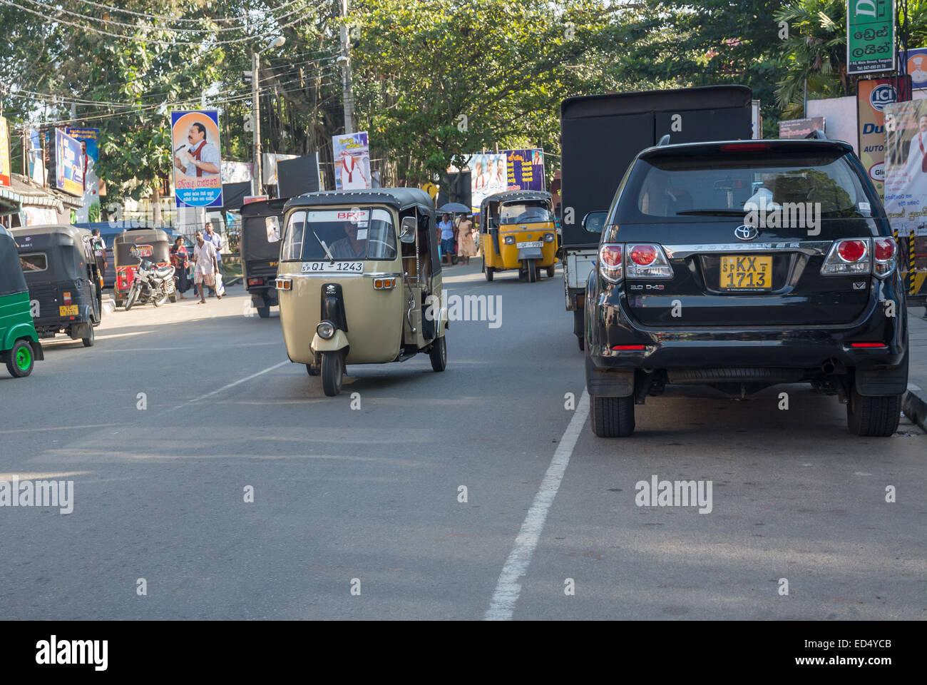 Street view con cartellone elettorale tuk tuk traffico e auto in Tangalle il 15 dicembre 2014 in Tangalle, Sri Lanka, in Asia. Foto Stock