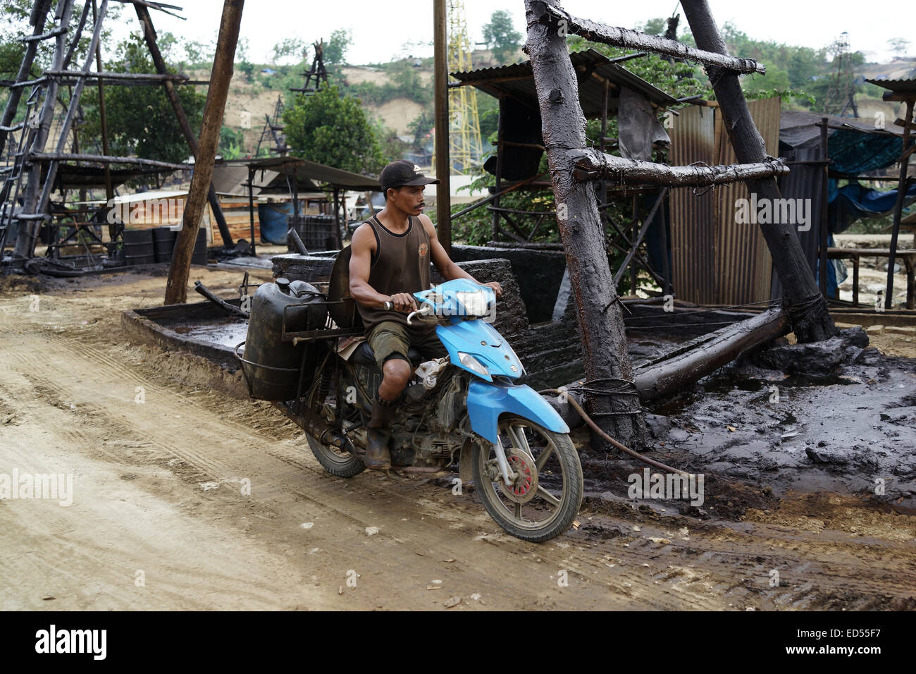 Gli uomini su motocicli trasporto gasolio raffinato per essere venduto nel sottodistretto Kedewan, Bojonegoro, Indonesia. Foto Stock