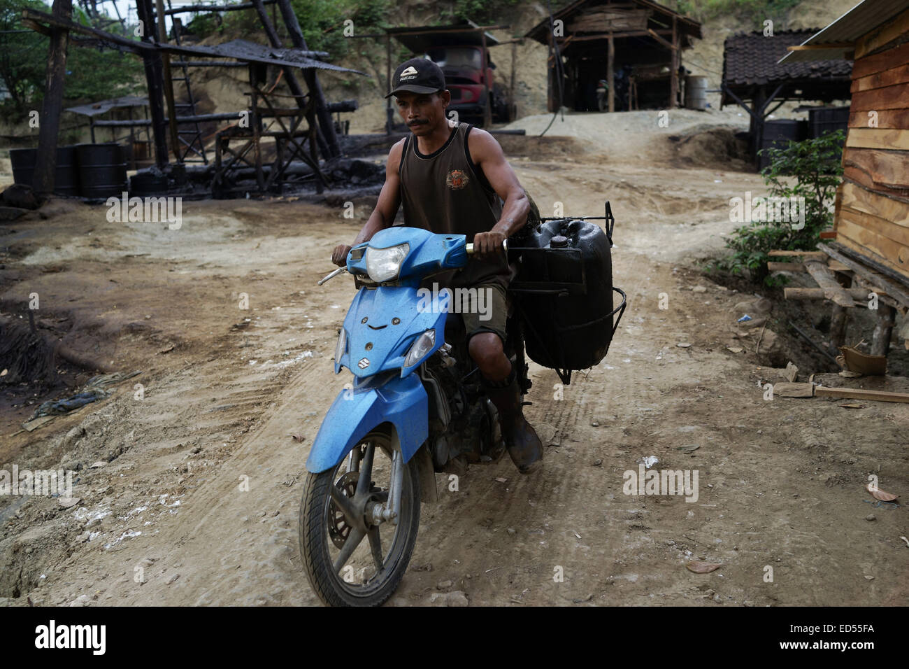 Gli uomini su motocicli trasporto gasolio raffinato per essere venduto nel sottodistretto Kedewan, Bojonegoro, Indonesia. Foto Stock