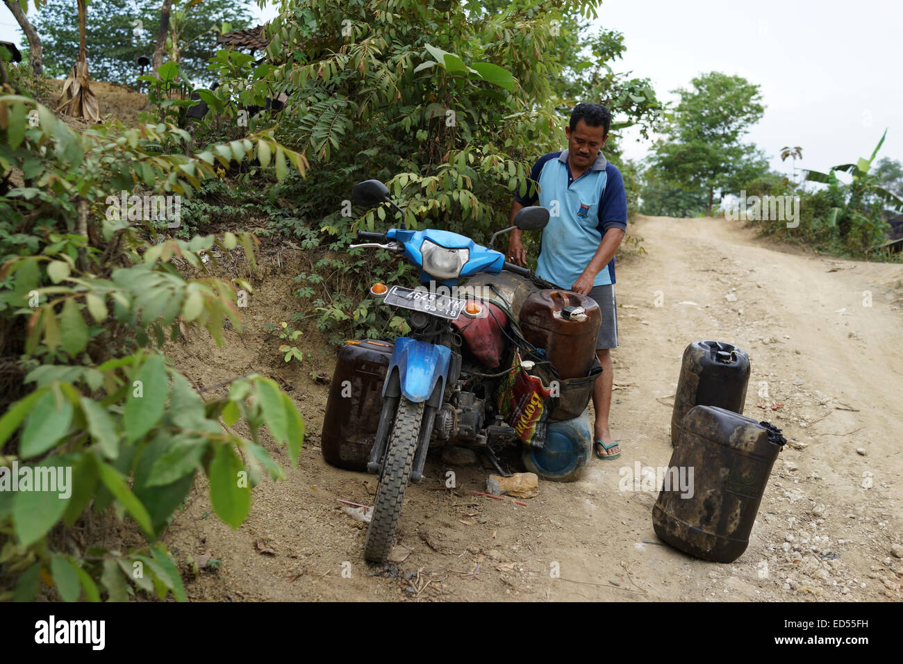 Gli uomini su motocicli trasporto gasolio raffinato per essere venduto nel sottodistretto Kedewan, Bojonegoro, Indonesia. Foto Stock