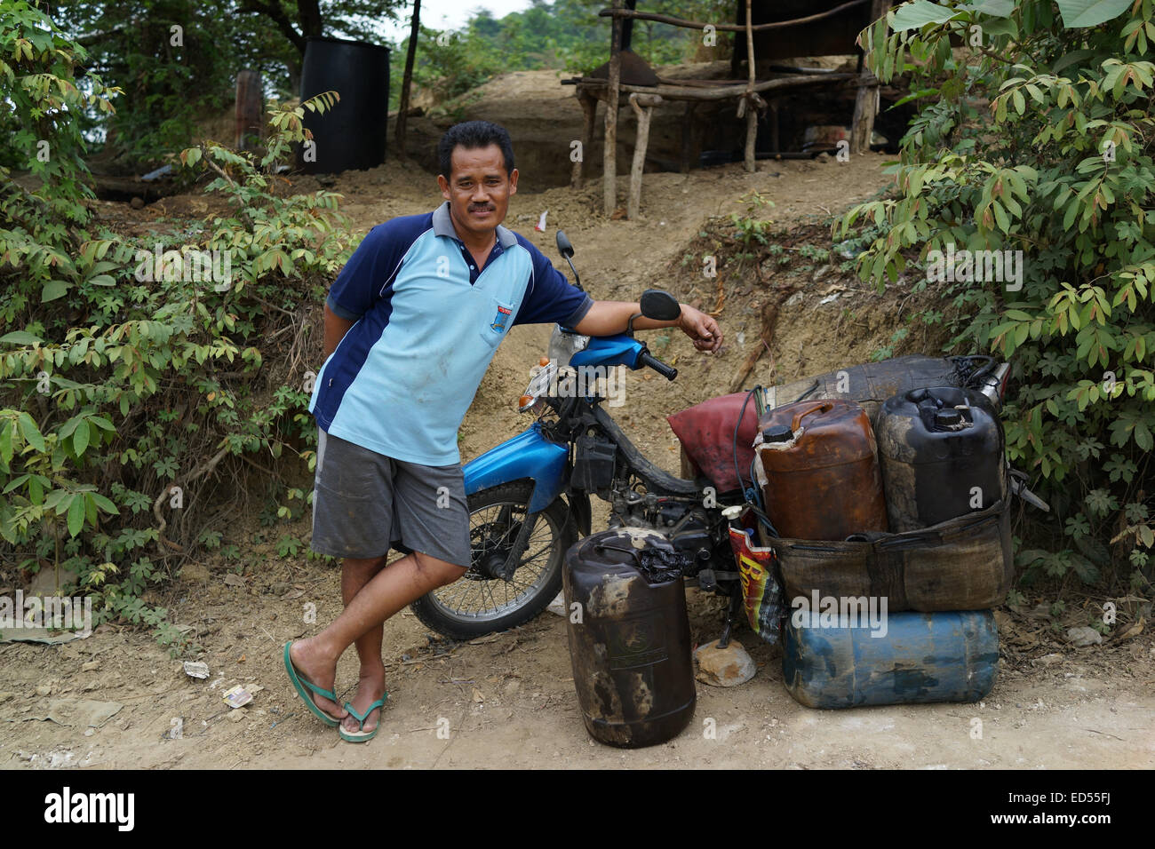 Gli uomini su motocicli trasporto gasolio raffinato per essere venduto nel sottodistretto Kedewan, Bojonegoro, Indonesia. Foto Stock