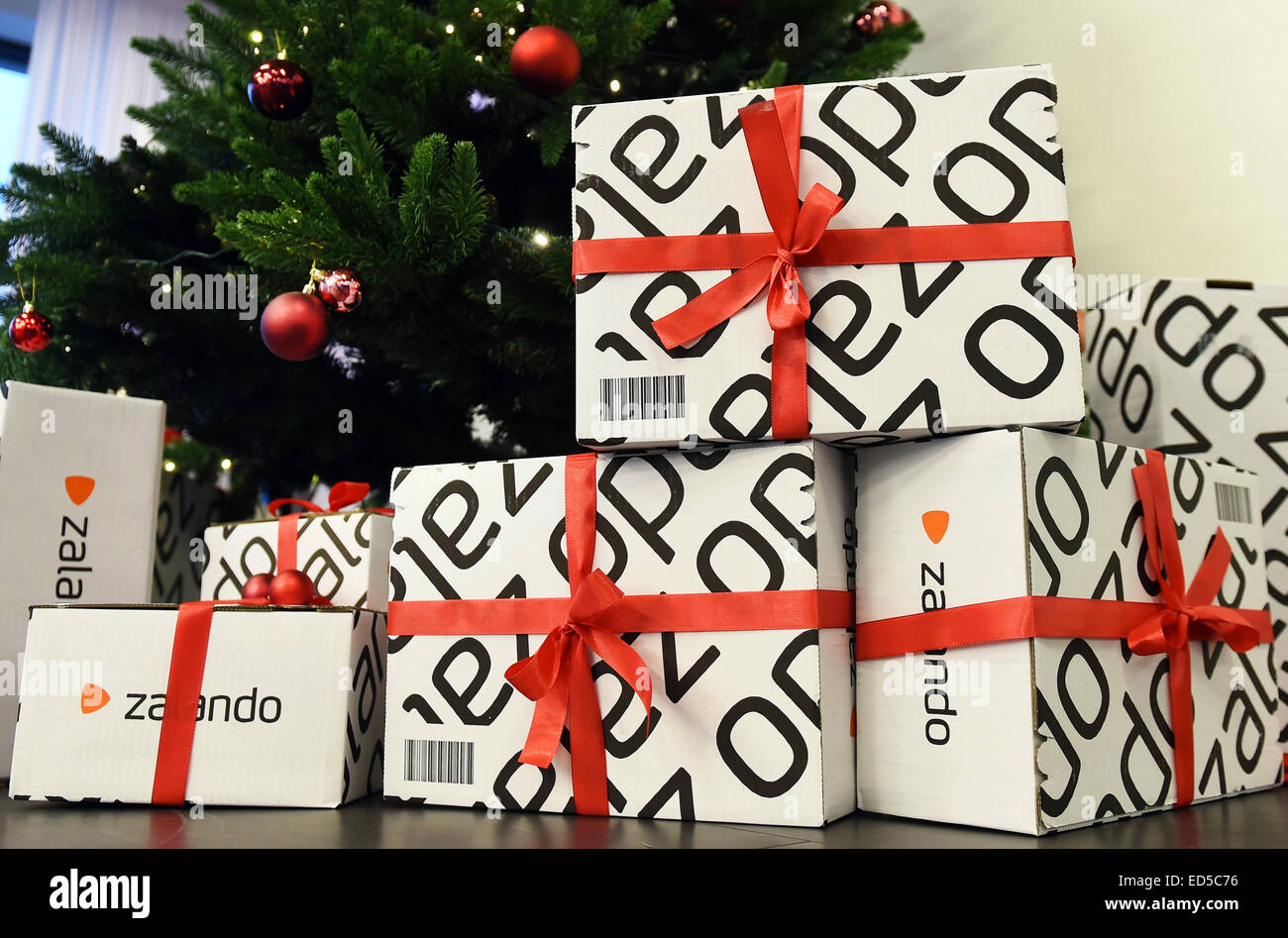 I pacchi con il logo del rivenditore online Zalando e nastri rossi si  trovano sotto un albero di Natale in tecnologia Zalando ufficio a Berlino,  Germania, 18 dicembre 2014. Foto: Jens Kalaene/dpa