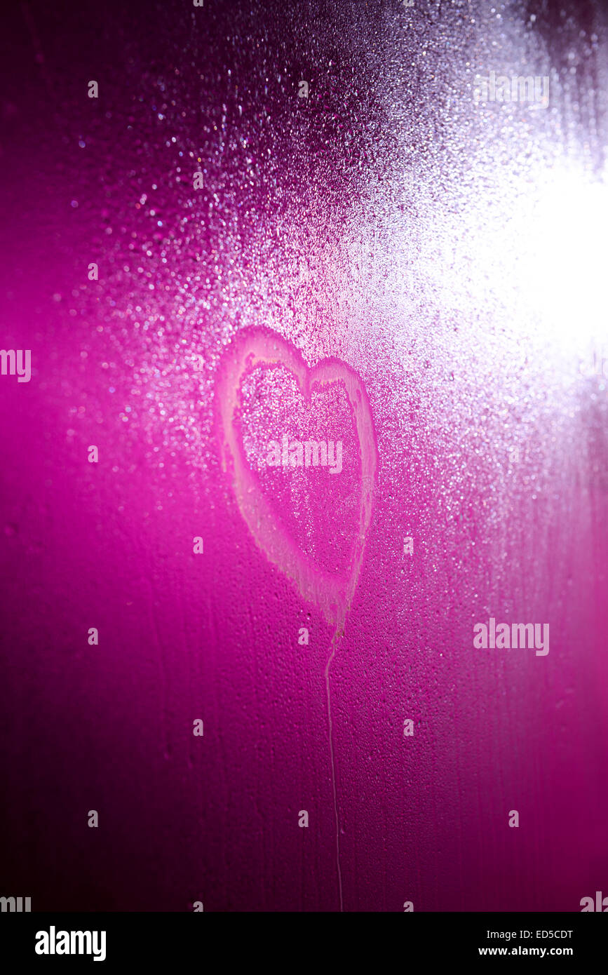 Cuore disegnato su steamy doccia porta con una rosa / viola di luce dietro di essa Foto Stock