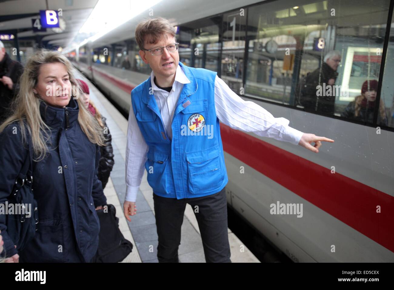 La testa di Bielefeld 'Bahnhofsmission' (lit. Stazione ferroviaria missione), un organizzazione per aiutare chi viaggia in treno e le persone in stato di bisogno, Marcel Bohnenkamp (R) parla di una donna che cerca di trovare la piattaforma di partenza per il suo treno. Foto: Oliver Krato/dpa Foto Stock