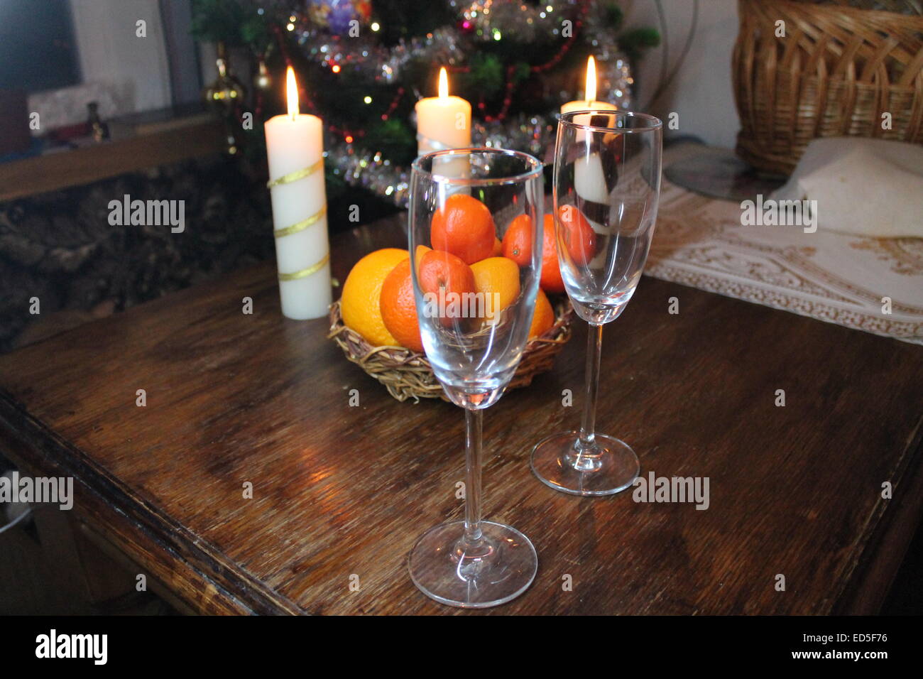 Due vetro cristallo sul tavolo , frutti maturi e la masterizzazione di tre candele bianche Foto Stock