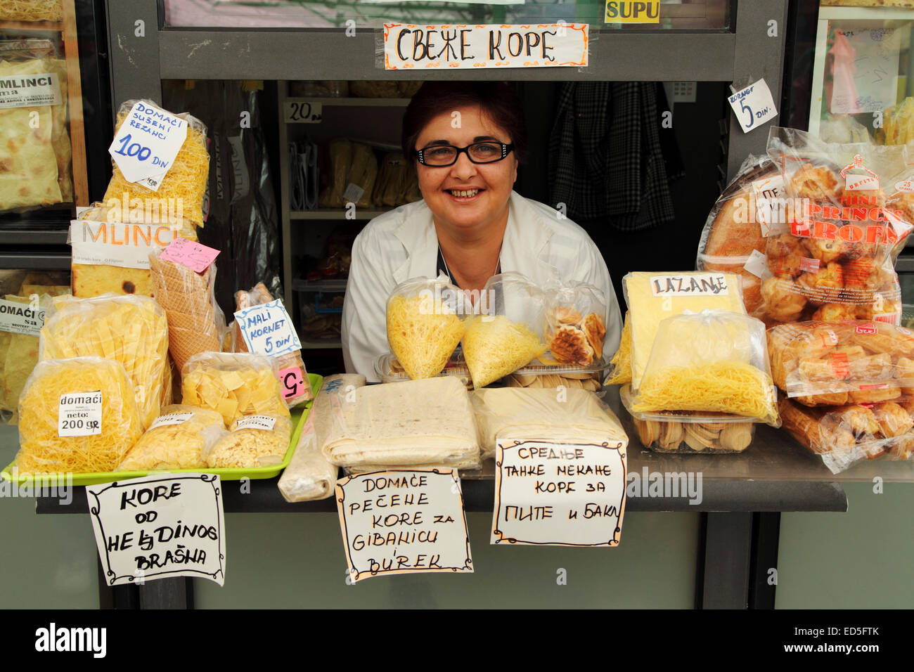Una donna ad una bancarella vendendo preparata di fresco pasta al mercato verde nel centro di Belgrado, Serbia. Il mercato è un popu Foto Stock