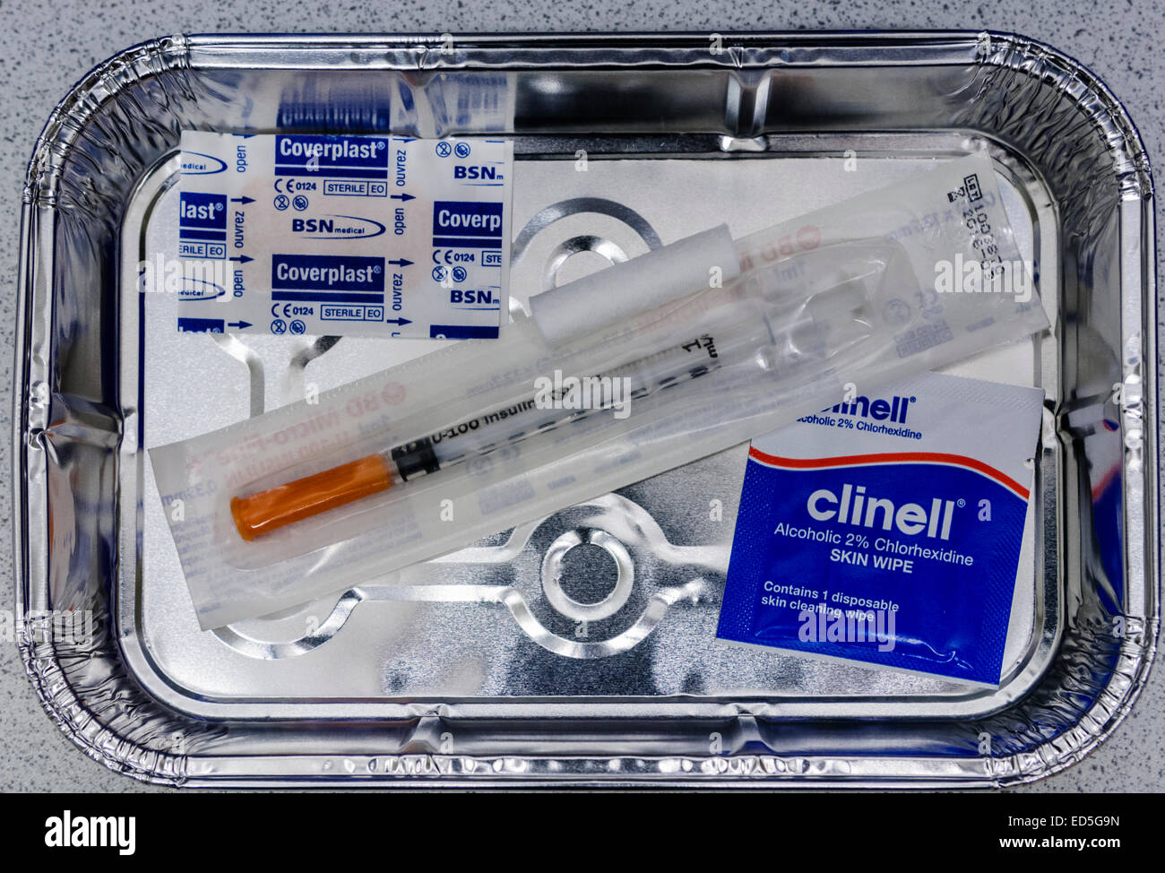 Vassoio di alluminio riempito con una siringa per insulina e altre apparecchiature pronto per la somministrazione di insulina a un paziente. Foto Stock