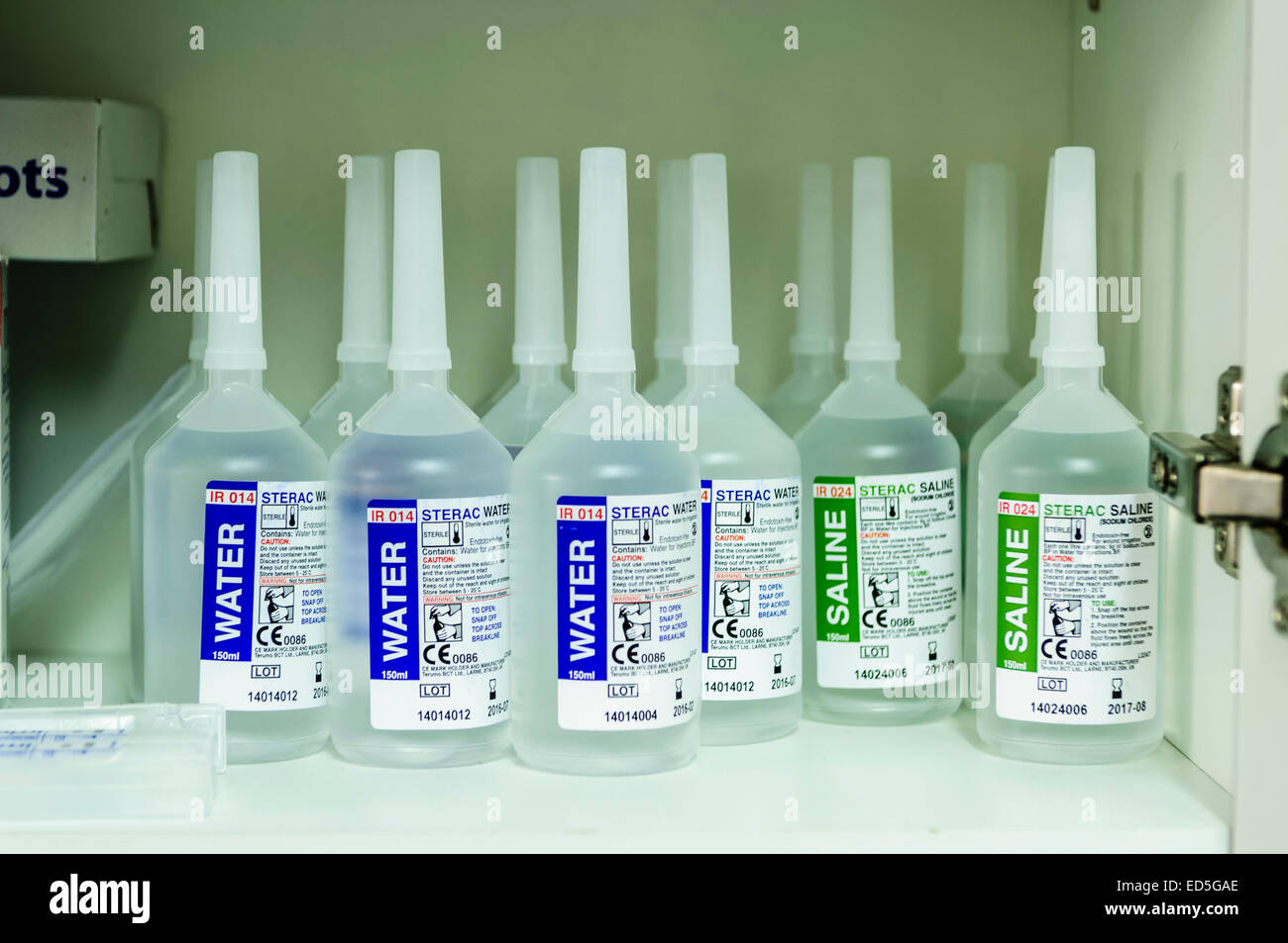 Bottiglie di acqua e soluzione salina nell'armadio di un ospedale sala clinica Foto Stock