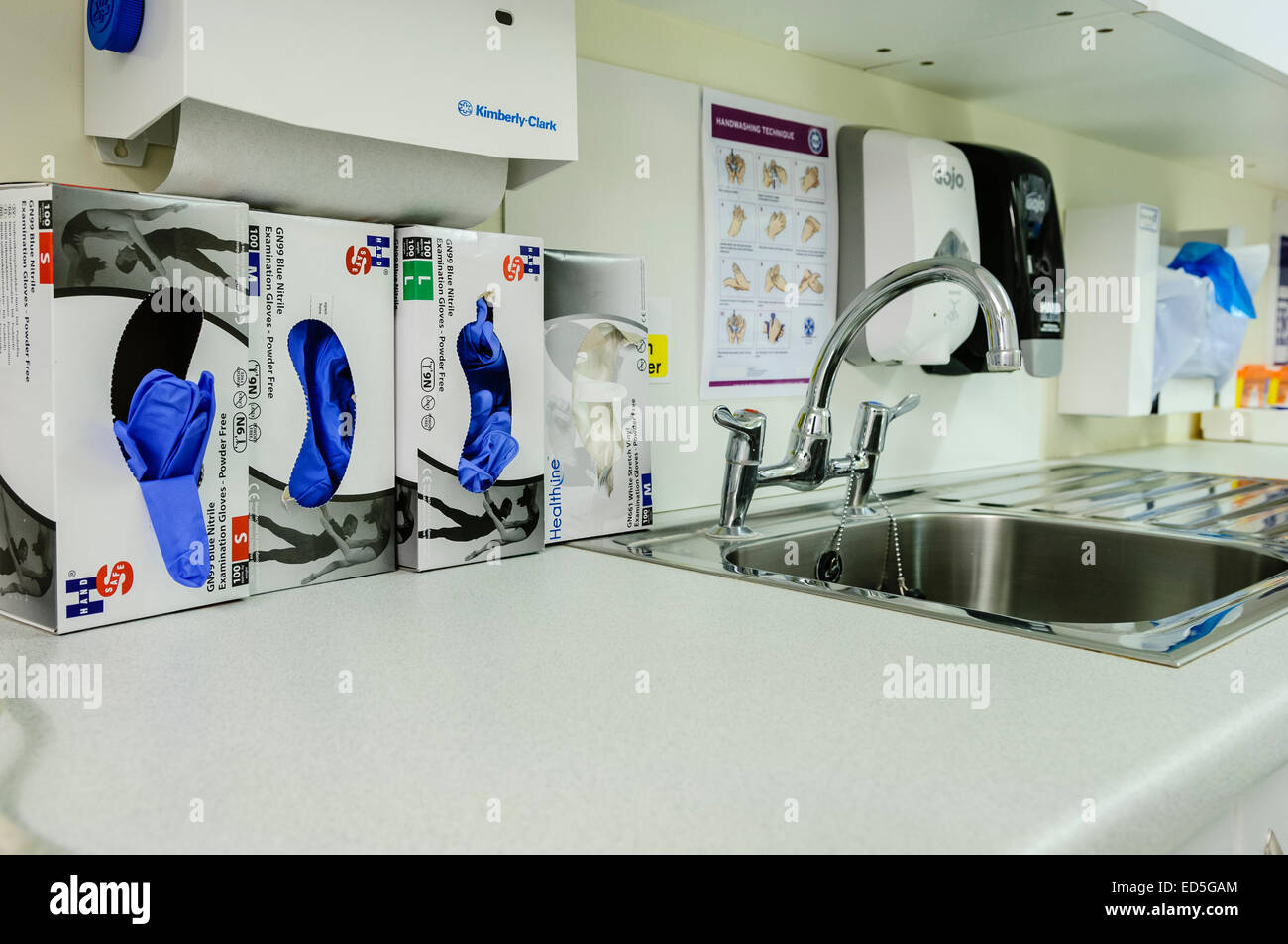 Blue nitrile Guanti medici accanto a una mano-stazione di lavaggio in un ospedale. Foto Stock