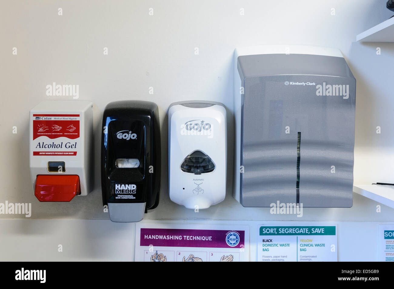 Gel a base d'alcool, pelle balsamo, sapone e asciugamani di carta in corrispondenza di una stazione di handwashing in un ospedale Foto Stock