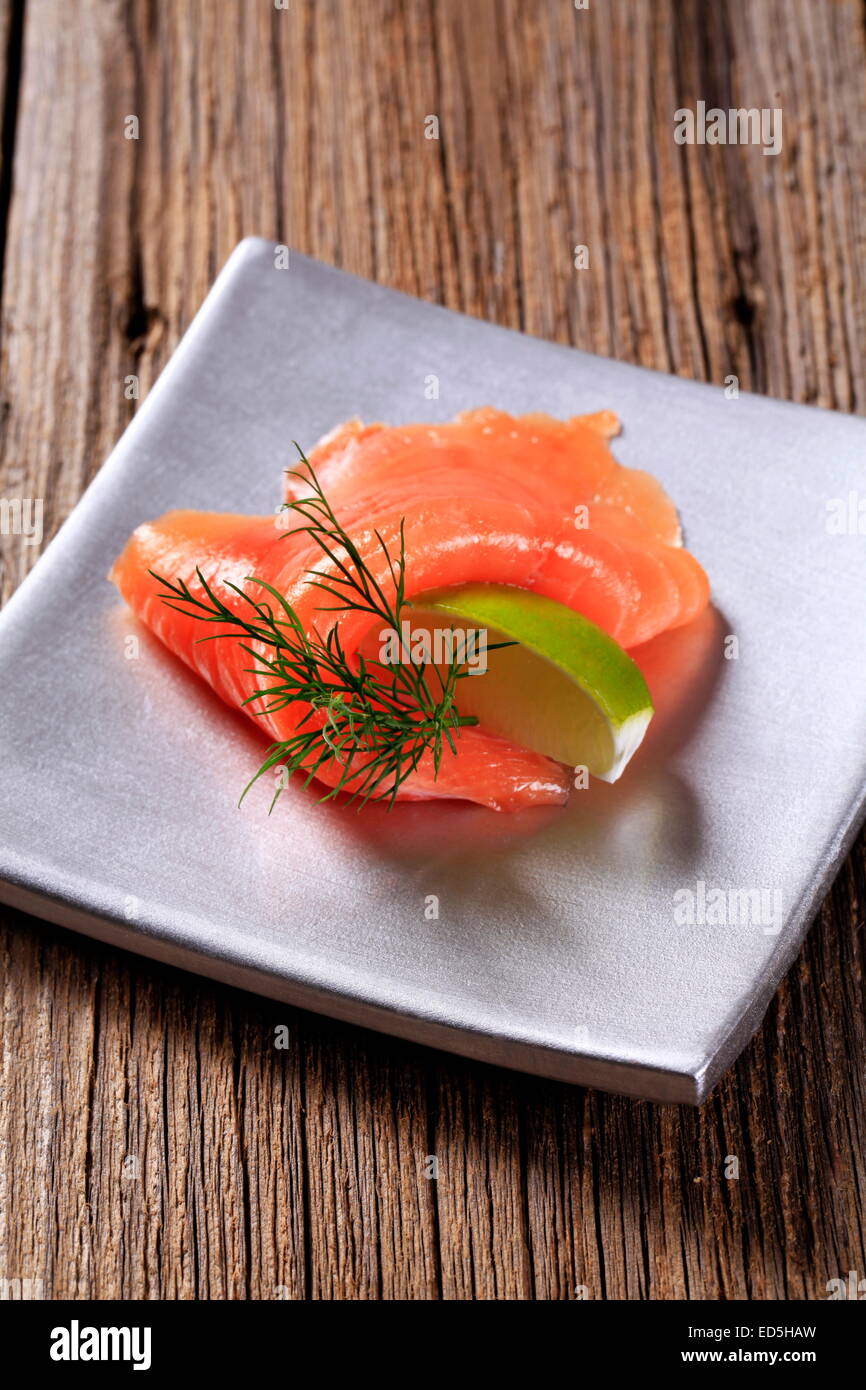 Strato sottile di salmone affumicato e il cuneo di calce Foto Stock