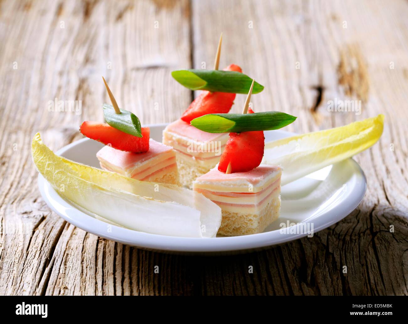 Prosciutto e formaggio tartine e foglie di insalata riccia Foto Stock