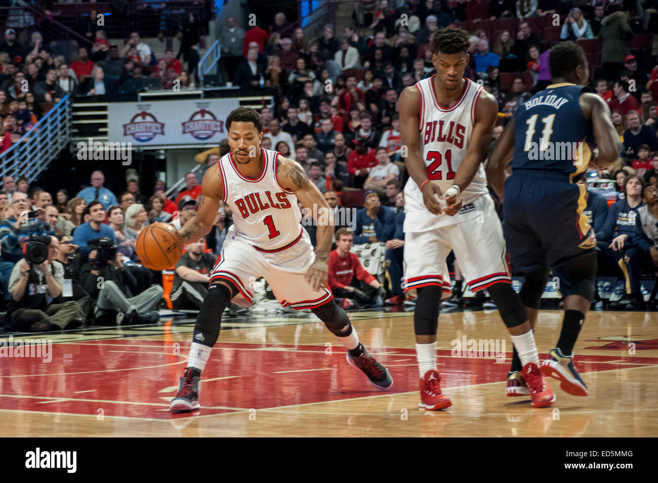 Chicago, Stati Uniti d'America. Il 27 dicembre 2014. New Orleans pellicani riprodurre il Chicago Bulls presso la United Center. Punteggio finale, pellicani 100, tori 107. Nella foto: tori' Derrick Rose (1) porta la sfera, protetto da Jimmy Butler (21). Credito: Stephen Chung/Alamy Live News Foto Stock