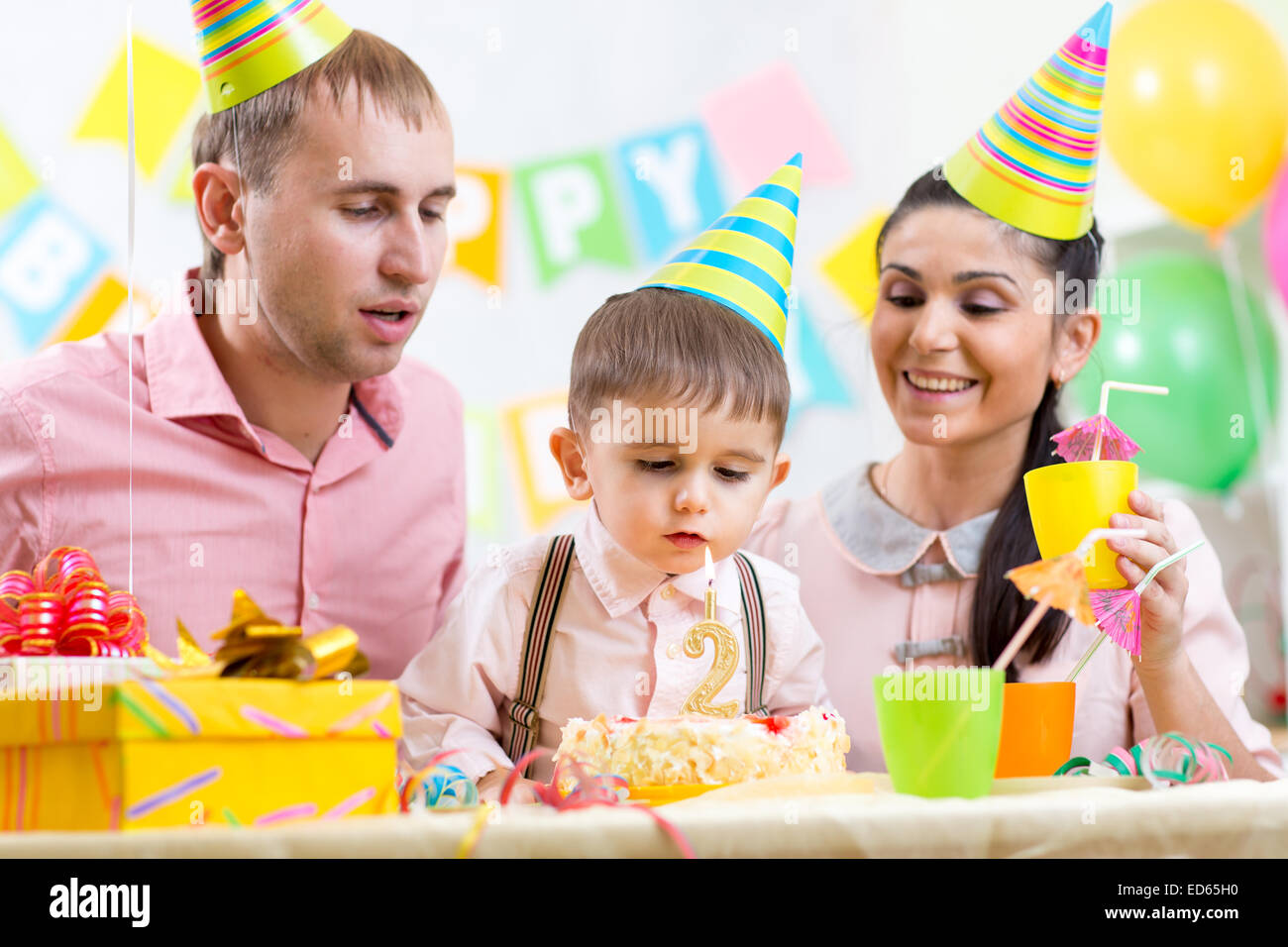 Il capretto con famiglia soffiando candela sulla torta di compleanno Foto Stock
