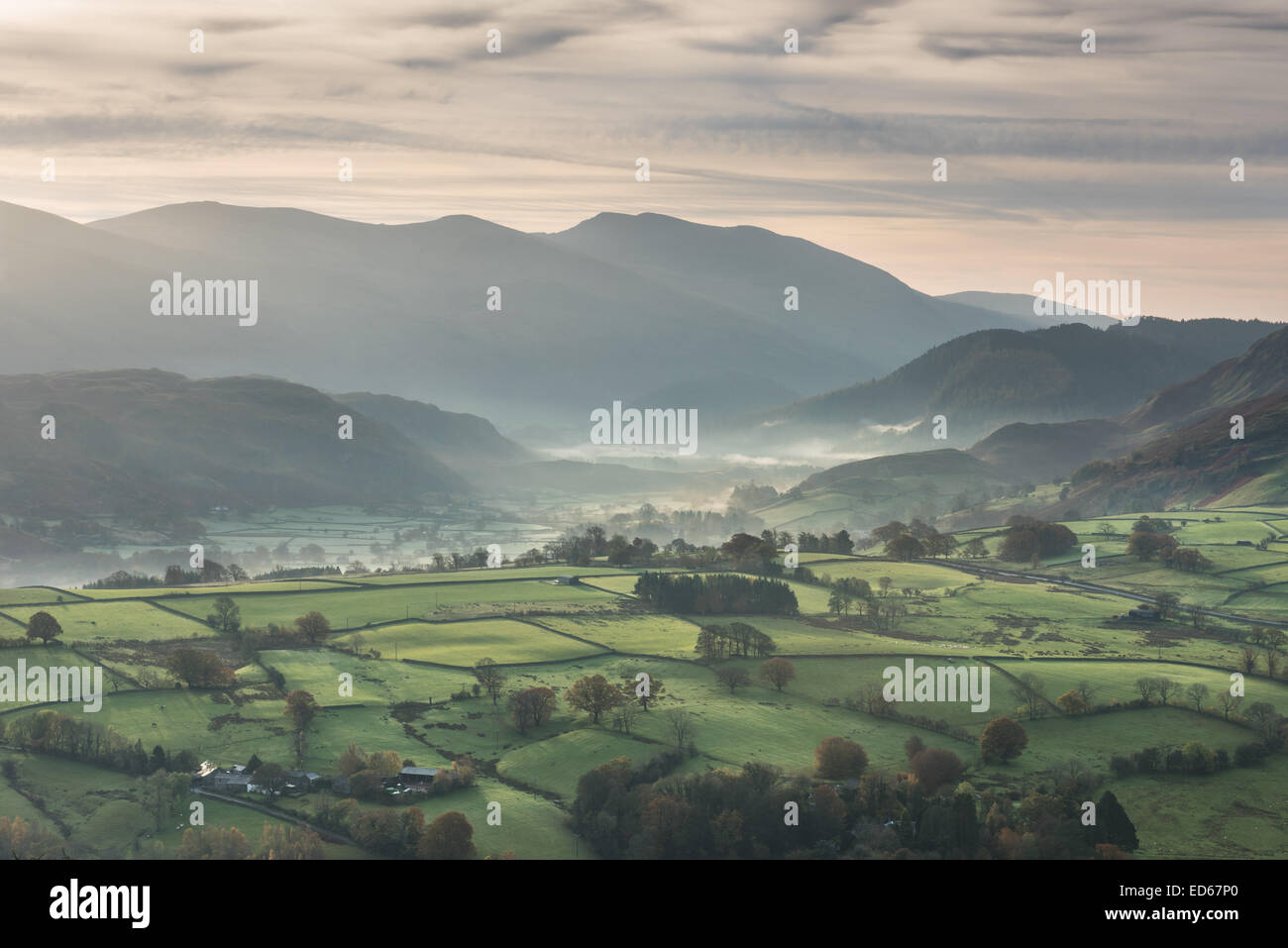 Vista da Latrigg su campi e nebbioso valley verso il sollevamento e Helvellyn, Lake District inglese Foto Stock