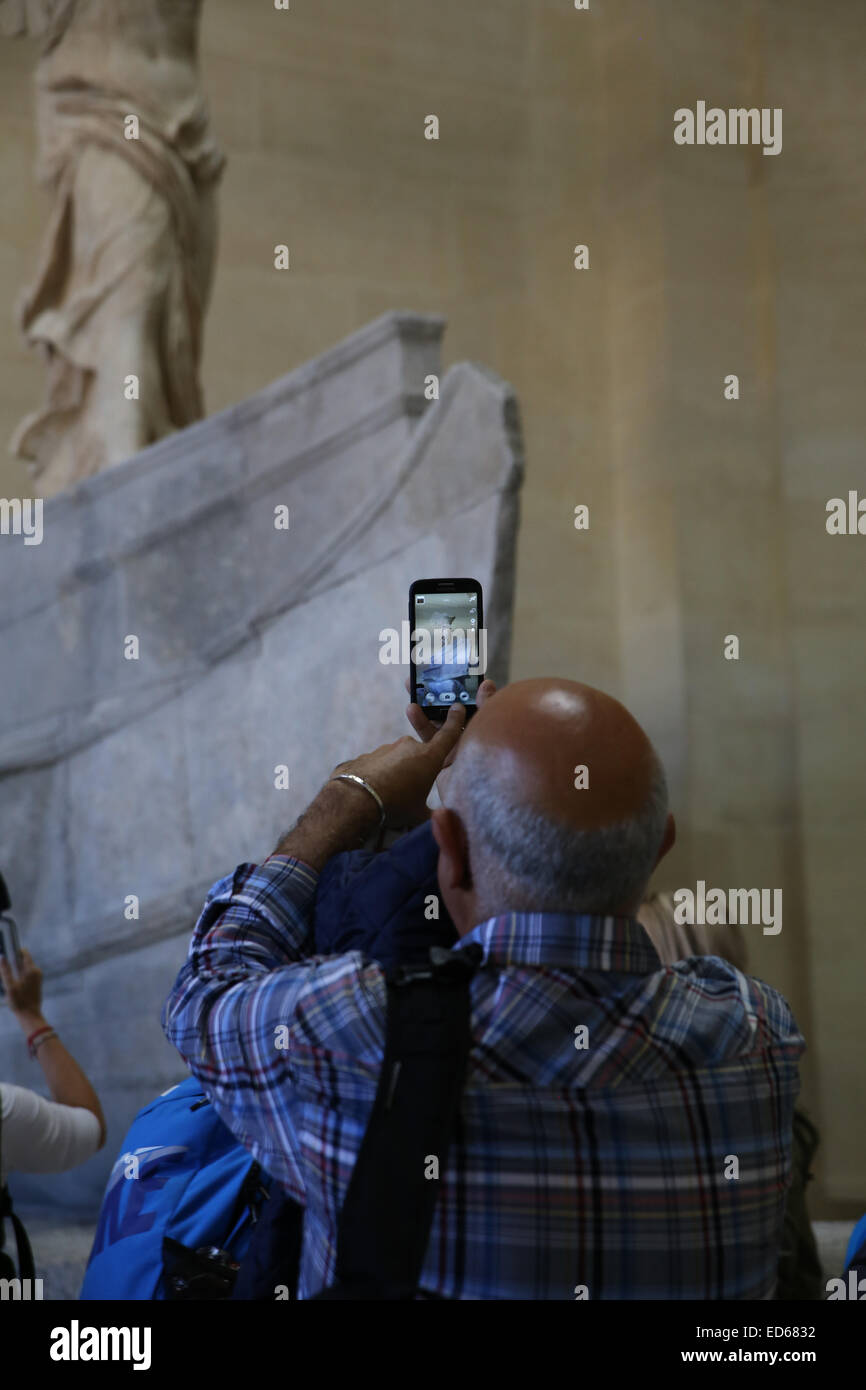 Il vecchio uomo prendendo foto all'interno del museo del Louvre Foto Stock