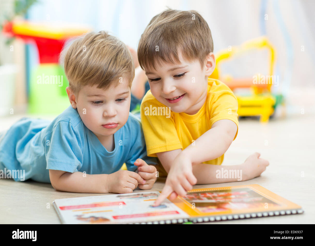 I bambini a leggere un libro a casa o stanza dei bambini Foto Stock