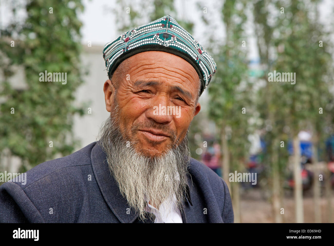Ritratto di uomo anziano con la barba di Uighur tribù in Kashgar / Kashi indossando un Doppa, provincia dello Xinjiang, Cina Foto Stock