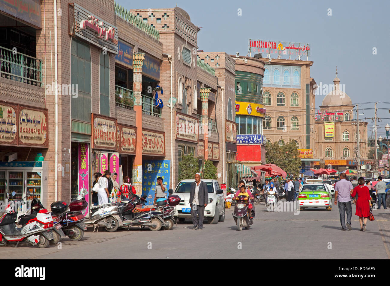Scooter nella trafficata strada per lo shopping in città Kashgar / Kashi, provincia dello Xinjiang, Cina Foto Stock