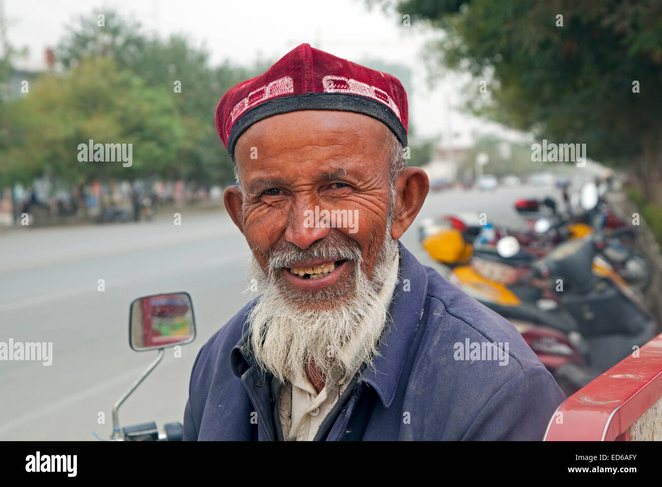 Close up ritratto di anziani Uyghur uomo con barba indossando doppa in Qiemo / Cherchen, oasi cittadina nella provincia dello Xinjiang, Cina Foto Stock
