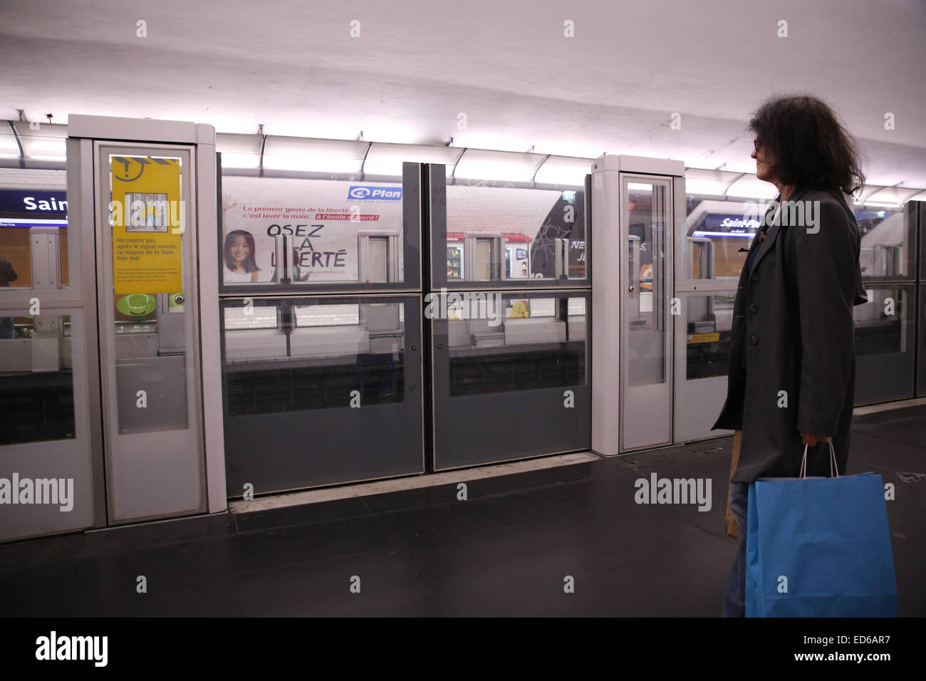La donna in attesa del treno della metropolitana di Parigi platform Foto Stock