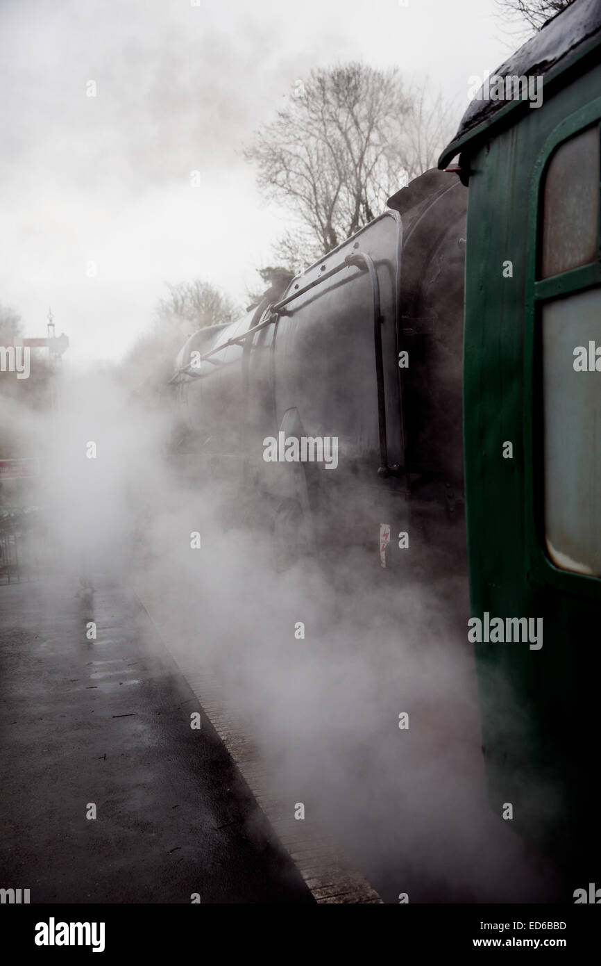 Conserve di BR Standard di Classe 9F 2-10-0 locomotiva a vapore vi attende la partenza tra le nuvole di vapore in Hampshire Foto Stock