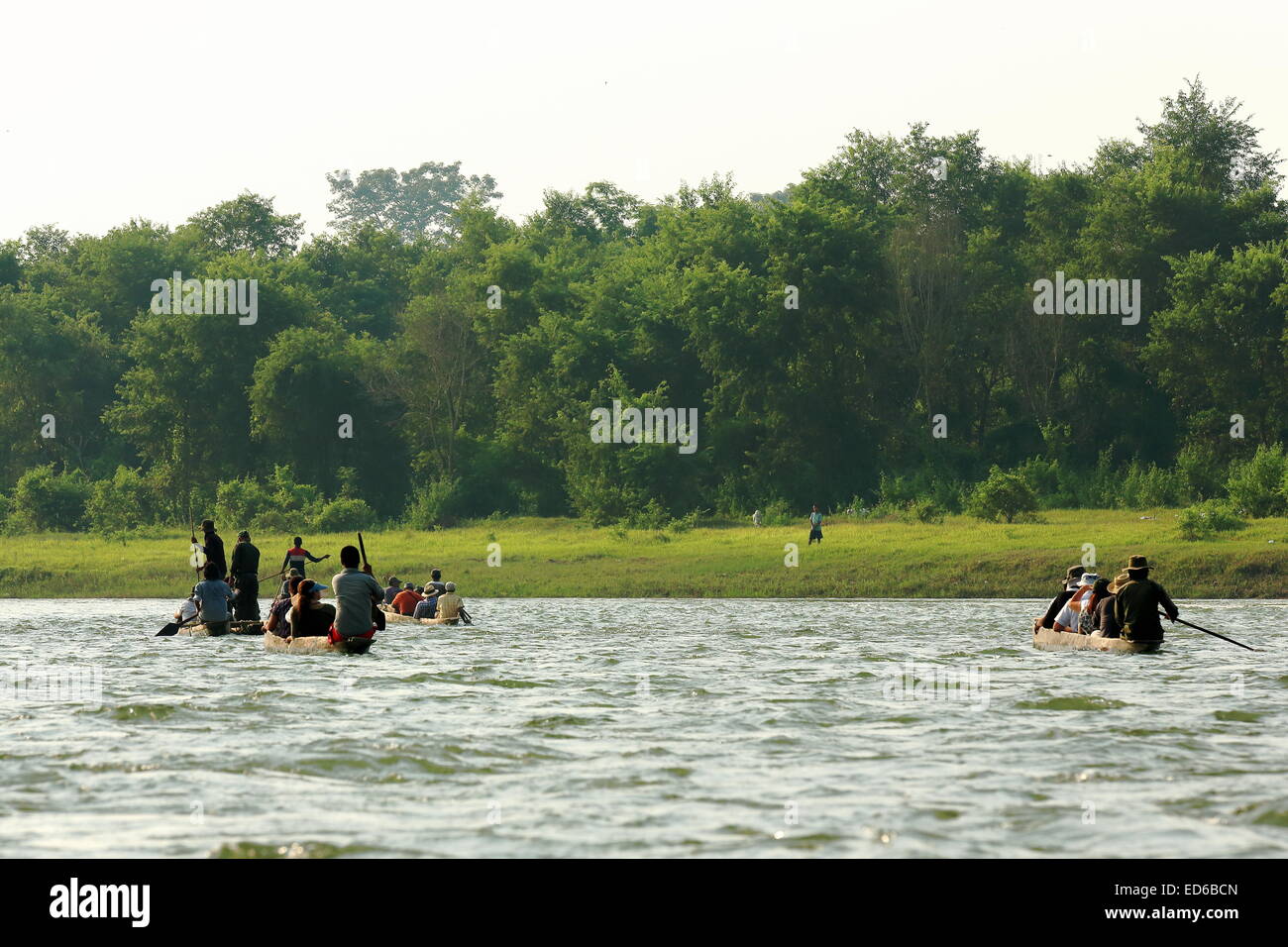 CHITWAN, Nepal - 14 ottobre: turisti su imbarcazioni a remi in legno visita il Terai area andando giù il fiume Rapti fluente attraverso Chitwan. Foto Stock