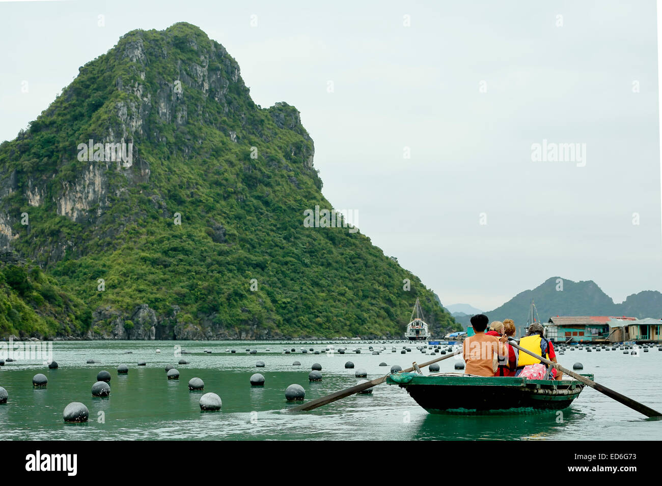 Turisti in fila in legno barche, Pearl Farm boe e calcare (Carso tumuli, Vung Vieng villaggio di pescatori, la baia di Ha Long, Vietnam Foto Stock