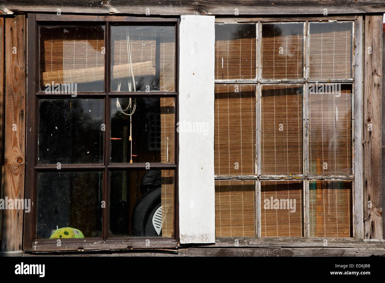 Una vecchia finestra in legno telaio con uno scorcio di un uccello arrabbiato toy visto attraverso la finestra Foto Stock