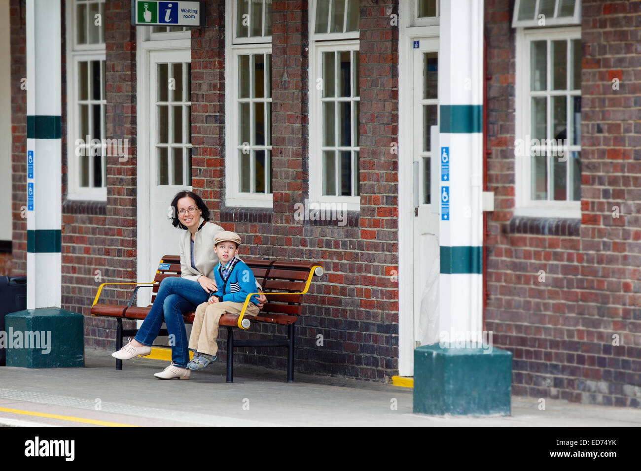 Giovane madre e figlio sulla stazione ferroviaria platform Foto Stock