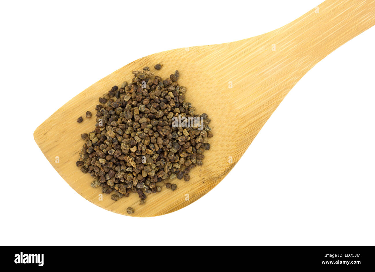 Chiudere la vista di un cucchiaio di legno tenendo un porzione di semi di cardamomo su uno sfondo bianco. Foto Stock