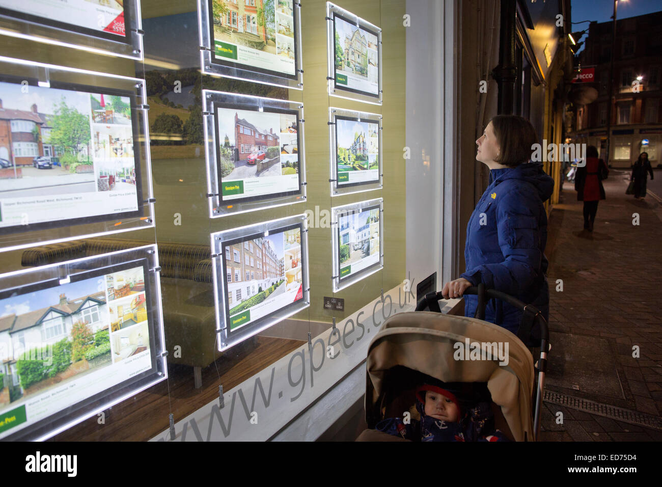 Donna e bambino guarda le proprietà pubblicizzato in un Agenti Immobiliari finestra, Richmond Upon Thames, Esterno Londra, Regno Unito Foto Stock