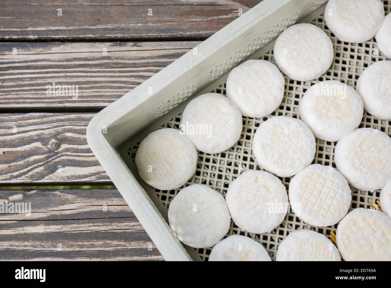 Insieme di piccoli capi di formaggio di capra crottin giacente su tavole di legno Foto Stock