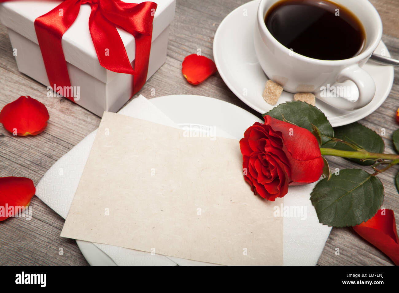 Cartolina sbozzato, una tazza di caffè e una rosa rossa sul tavolo Foto Stock