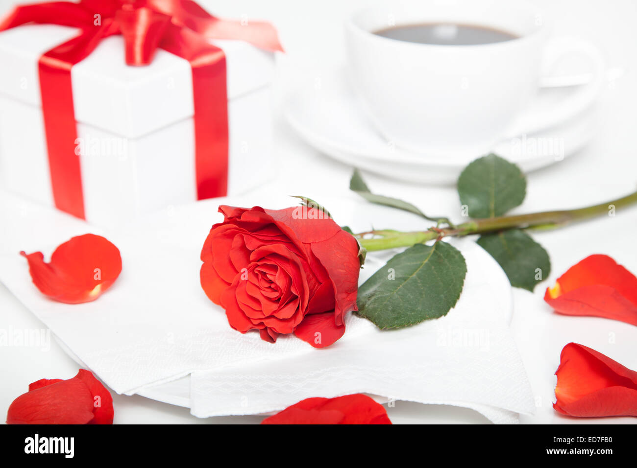 Red Rose, presente casella e tazza di caffè sul tavolo bianco Foto Stock