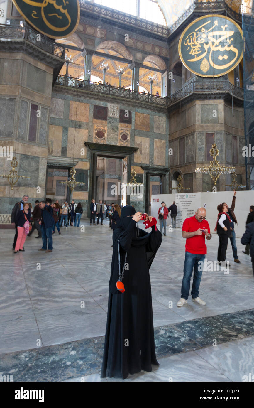 Donna musulmana a Hagia Sophia, Ayasofya Muzesi museo della moschea di indossare niqab utilizza lo smartphone scattare fotografie, Istanbul, Turchia Foto Stock
