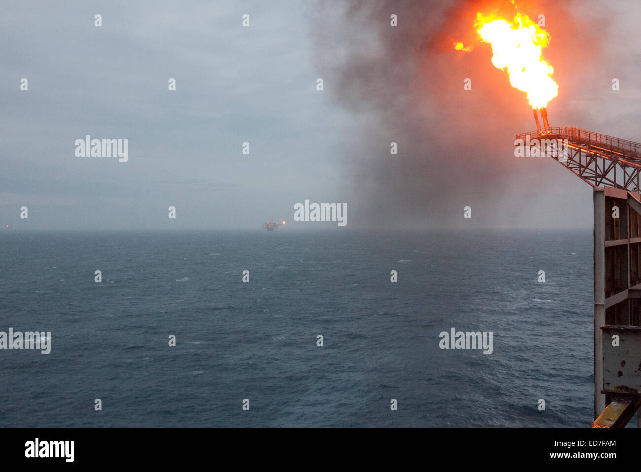 Il petrolio del Mare del Nord rig flare. gas rig in distanza. Credito: lee ramsden / alamy Foto Stock