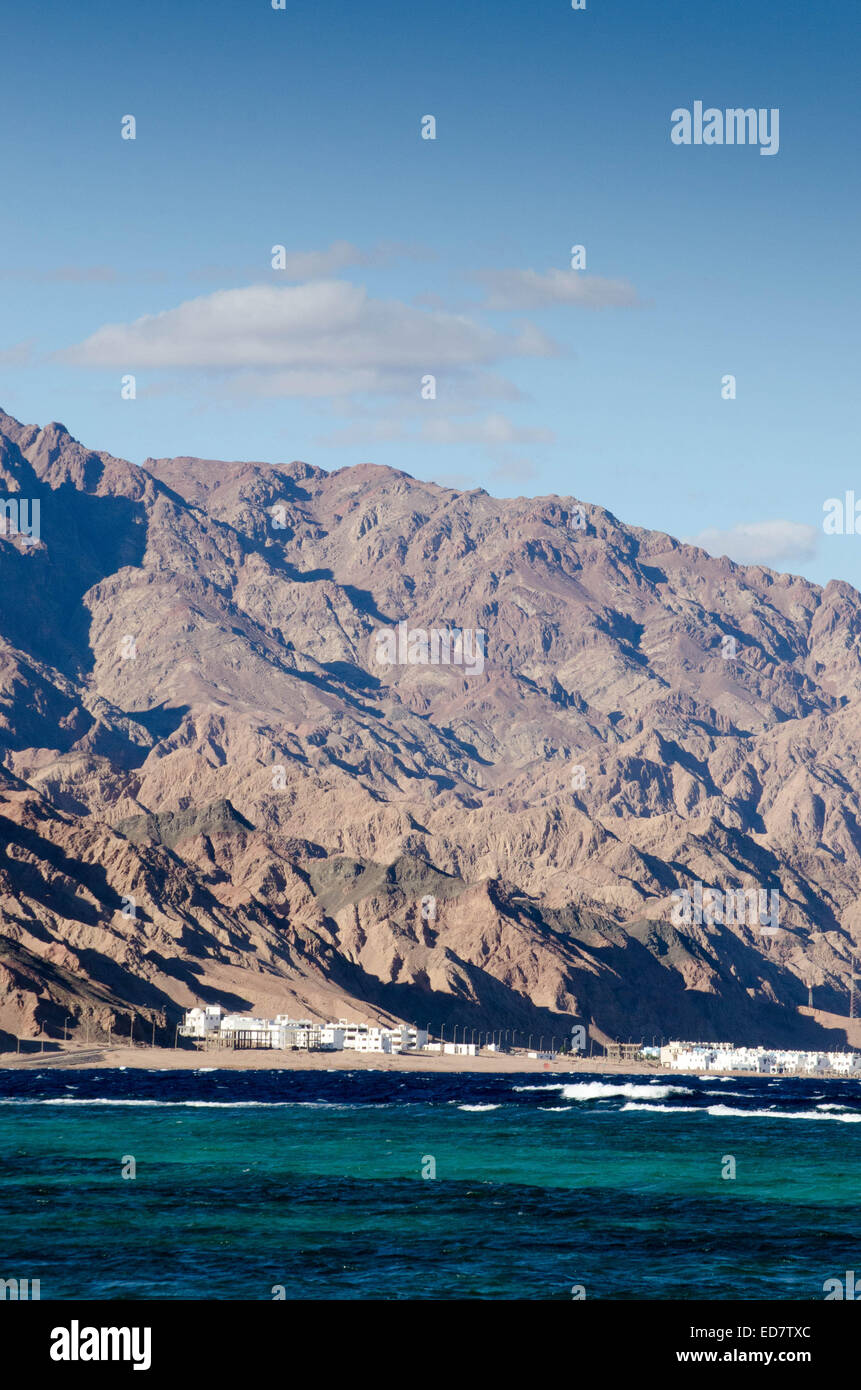 Montagne e con un piccolo insediamento al di sotto di esse, accanto al Mar Rosso, Egitto Foto Stock