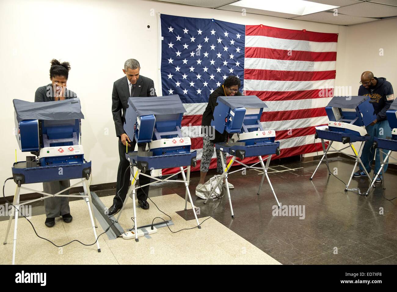 Il Presidente Usa Barack Obama getta il suo voto durante il voto anticipato il Martin Luther King Jr. Centro Comunitario Ottobre 20, 2014 in Chicago, IL. Compagno di elettore Mike Jones, estrema destra, quipped 'Mr. Presidente, non toccare la mia ragazza' quando il presidente concluso la votazione, ha raggiunto oltre e Cooper ha dato un bacio sulla guancia. Foto Stock