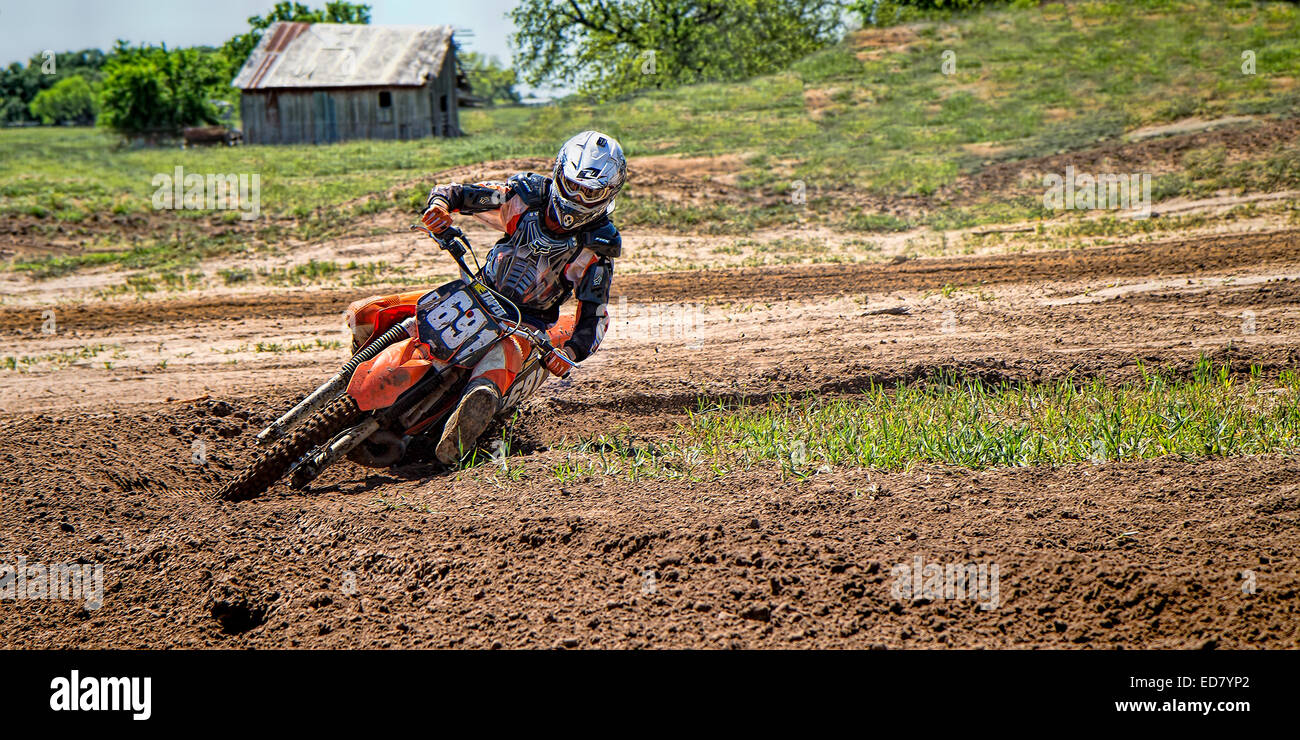 Il pilota di Motocross duro in curva su una pratica via Foto Stock