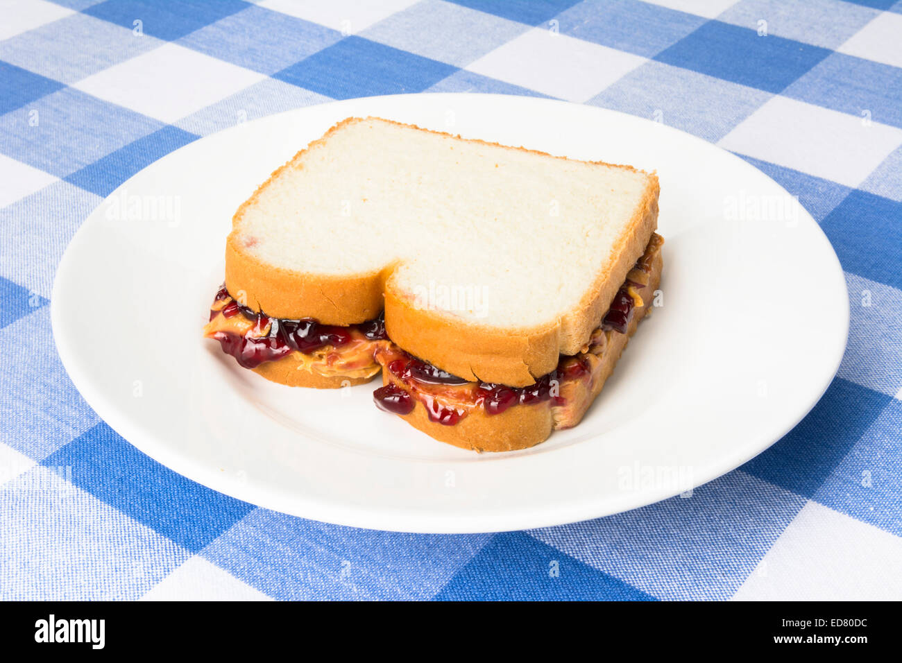 Un delizioso burro di arachidi e jelly sandwich con marmellata di uva pronto per essere consumato durante la pausa pranzo. Foto Stock