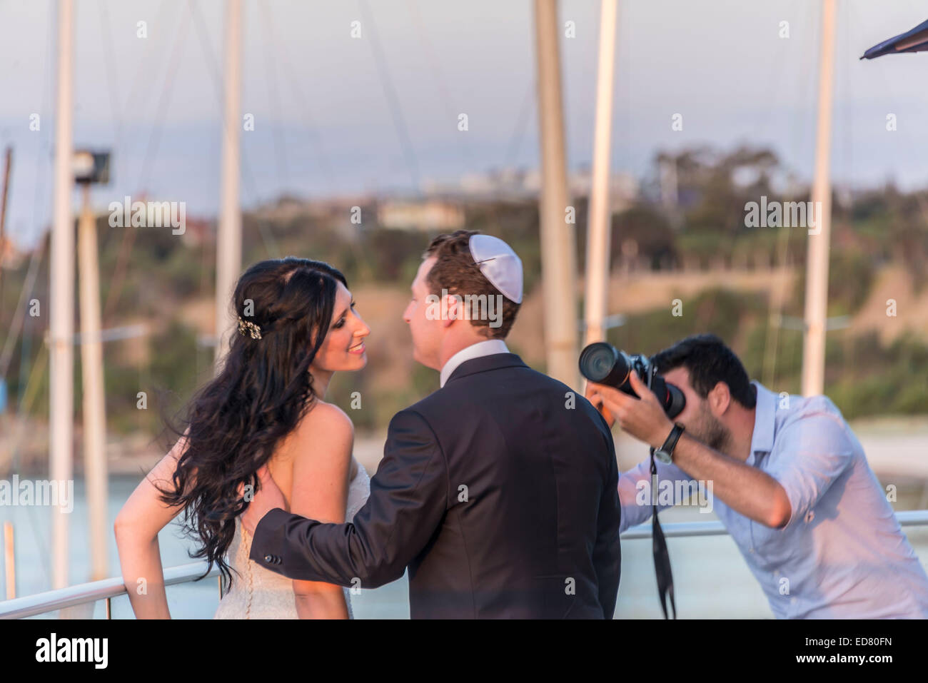 Jewish sposa e lo sposo a yacht club sulla spiaggia di baciare Foto Stock