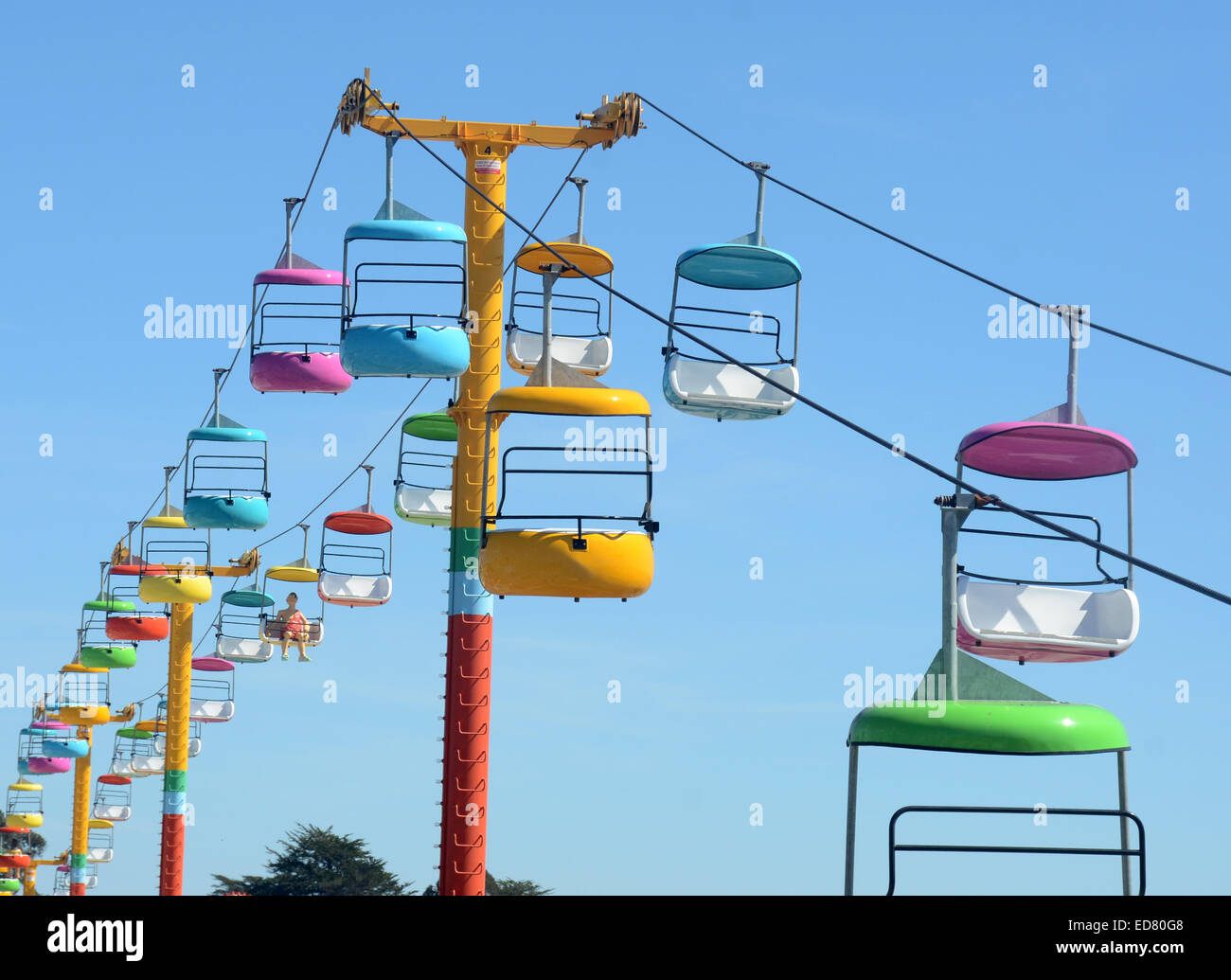 Sedili colorati dal parco dei divertimenti di corsa contro il cielo blu Foto Stock