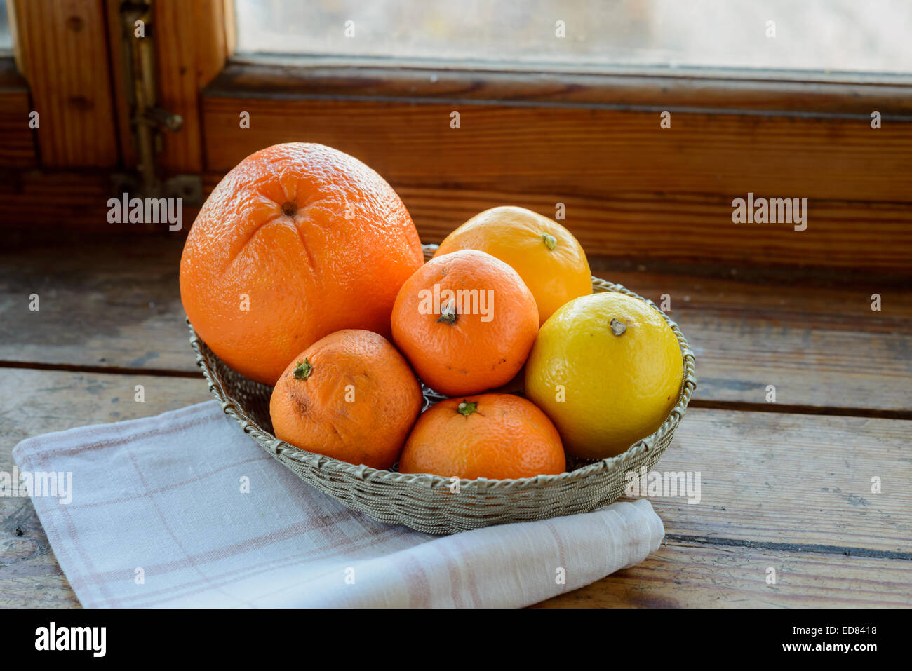 Arancione, tangerini e limone in filigrana d'argento cesto con un tovagliolo da tavola Foto Stock