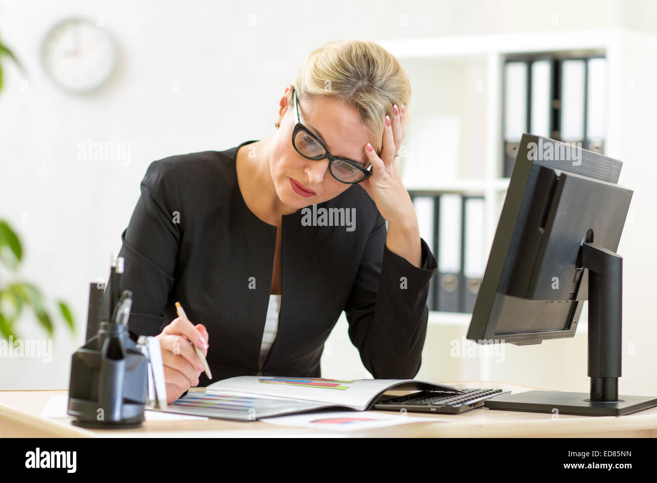 Business donna guardando i documenti aziendali in ufficio Foto Stock