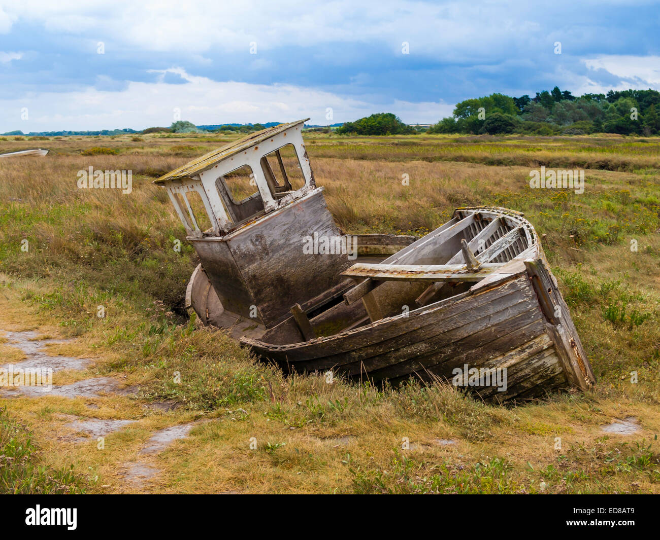 Un vecchio derelitti decadendo abbandonato la barca di legno su una palude salata a Thornham North Norfolk Foto Stock