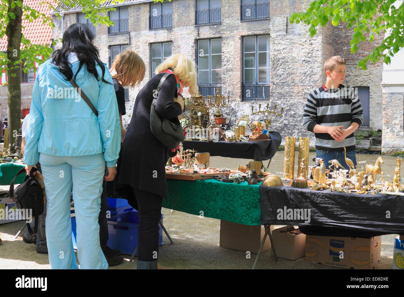 Persone (tre donna adulta) cercando di acquistare alcuni vecchi (usato) oggetti antichi in pulci Mercato Antiquariato bazaar a Bruges, Belgio Foto Stock