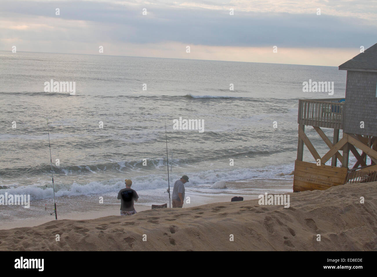 Due pescatori di pesce companionably insieme nell'oceano al tramonto su un Outer Banks beach in Carolina del Nord Foto Stock