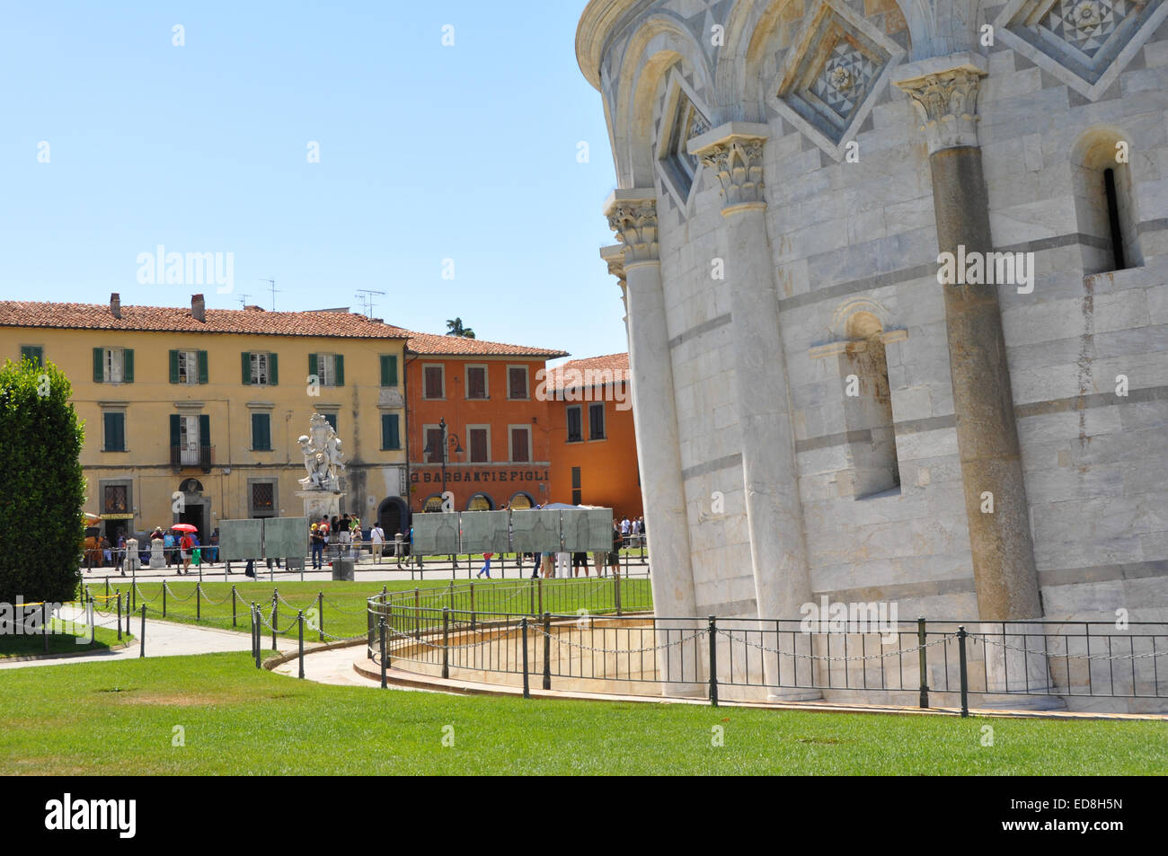 L'angolo della torre pendente di Pisa in contrasto contro il montante edifici della città Foto Stock