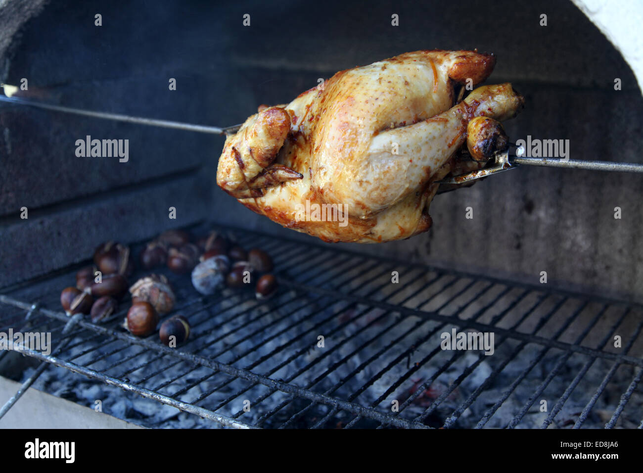 Un girarrosto pollo arrosto e castagne arrostite sul barbeque rende un ottimo pasto di Natale Foto Stock